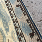 Close-up of the blue vintage Turkish distressed rug showing traditional details, hand-knotted weave, wool and cotton and low pile.