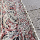 Close-up of the blue vintage Turkish distressed rug showing traditional details, hand-knotted weave, wool and cotton and low pile.