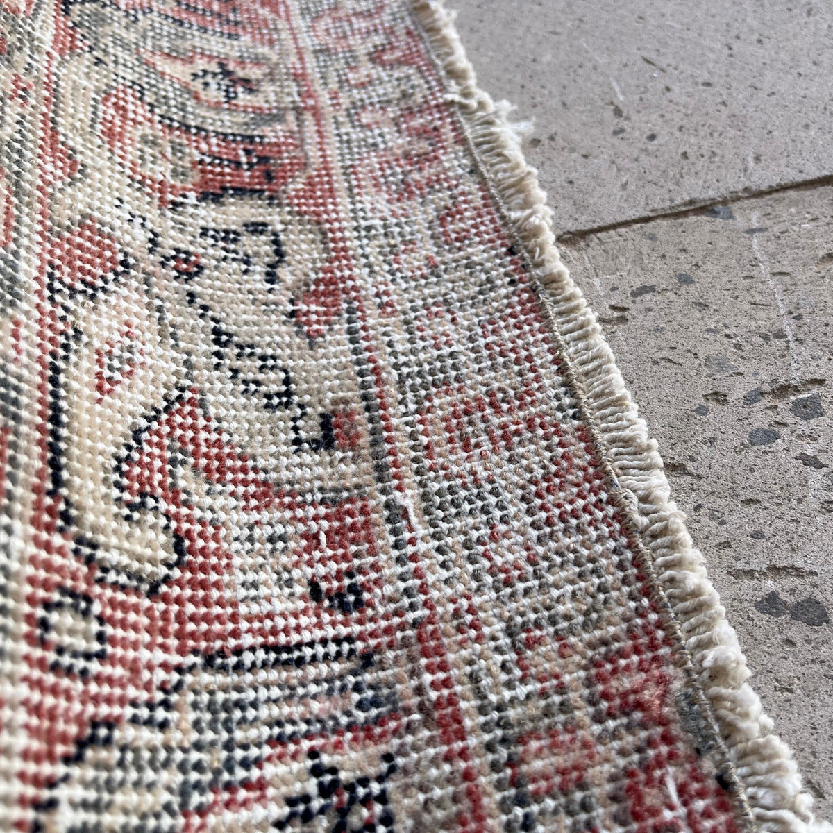 Close-up of the blue vintage Turkish distressed rug showing traditional details, hand-knotted weave, wool and cotton and low pile.