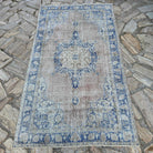 Blue 4' x 7' vintage Turkish distressed rug in wool and cotton, shown on the floor.