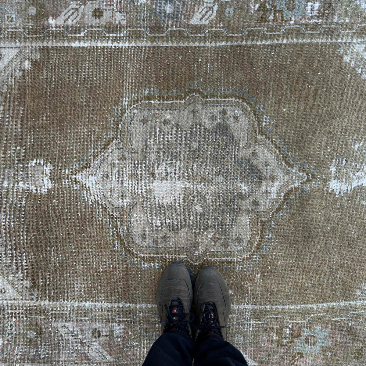 1970s brown vintage Turkish distressed rug with traditional design, hand-knotted weave and low pile.