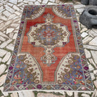 Pale Red 4' x 7' vintage Turkish distressed rug in wool and cotton, shown on the floor.