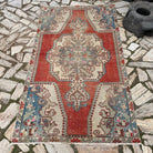 Red 4' x 7' vintage Turkish distressed rug in wool and cotton, shown on the floor.
