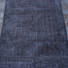 Close-up of the red vintage distressed rug showing floral details, hand-knotted weave, wool and cotton and low pile.