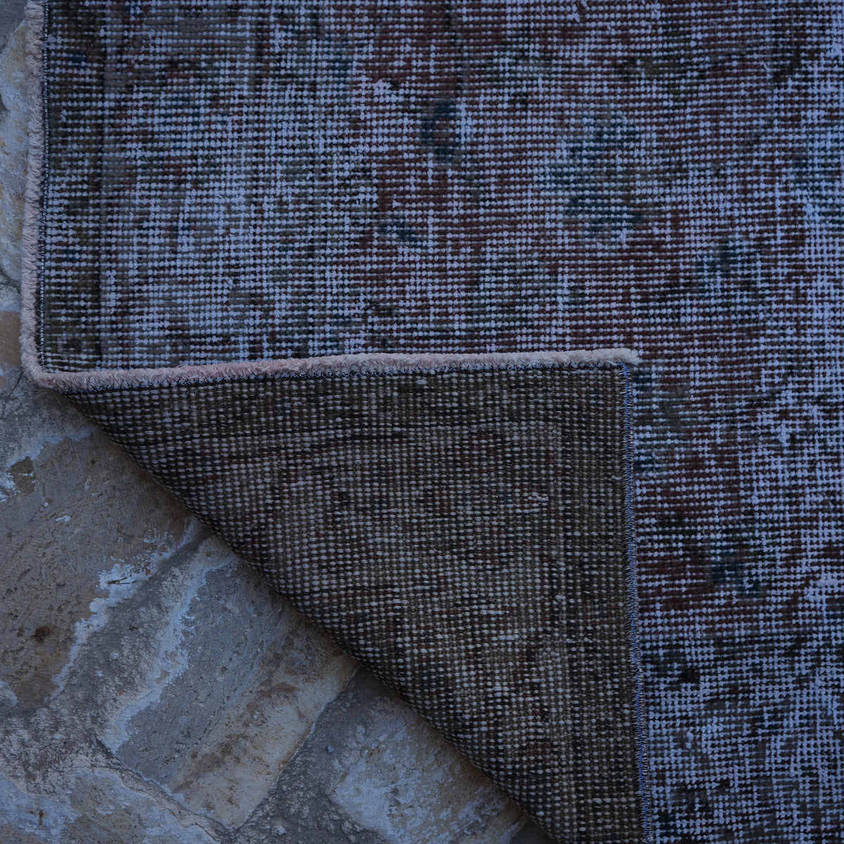 1970s red vintage distressed rug with floral design, hand-knotted weave and low pile.