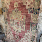 1970s red vintage Turkish distressed rug with traditional design, hand-knotted weave and low pile.