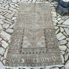 Beige 4' x 8' vintage Turkish distressed rug in wool and cotton, shown on the floor.