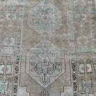 1970s beige vintage Turkish distressed rug with neutral design, hand-knotted weave and low pile.