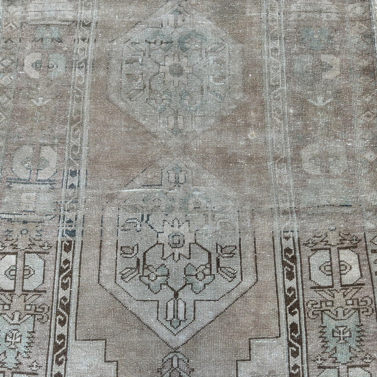 1970s beige vintage Turkish distressed rug with neutral design, hand-knotted weave and low pile.