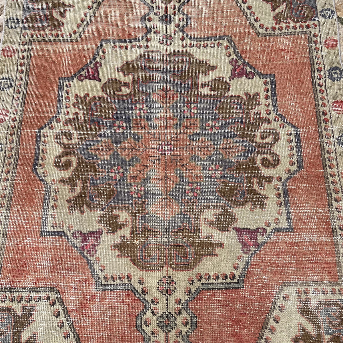 1970s orange vintage Turkish distressed rug with traditional design, hand-knotted weave and low pile.