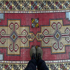 1970s red vintage Turkish distressed rug with traditional design, hand-knotted weave and low pile.