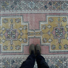 1970s pink vintage Turkish distressed rug with traditional design, hand-knotted weave and low pile.
