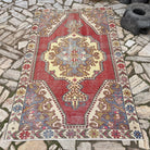 Red 5' x 7' vintage Turkish distressed rug in wool and cotton, shown on the floor.