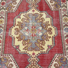 1970s red vintage Turkish distressed rug with traditional design, hand-knotted weave and low pile.