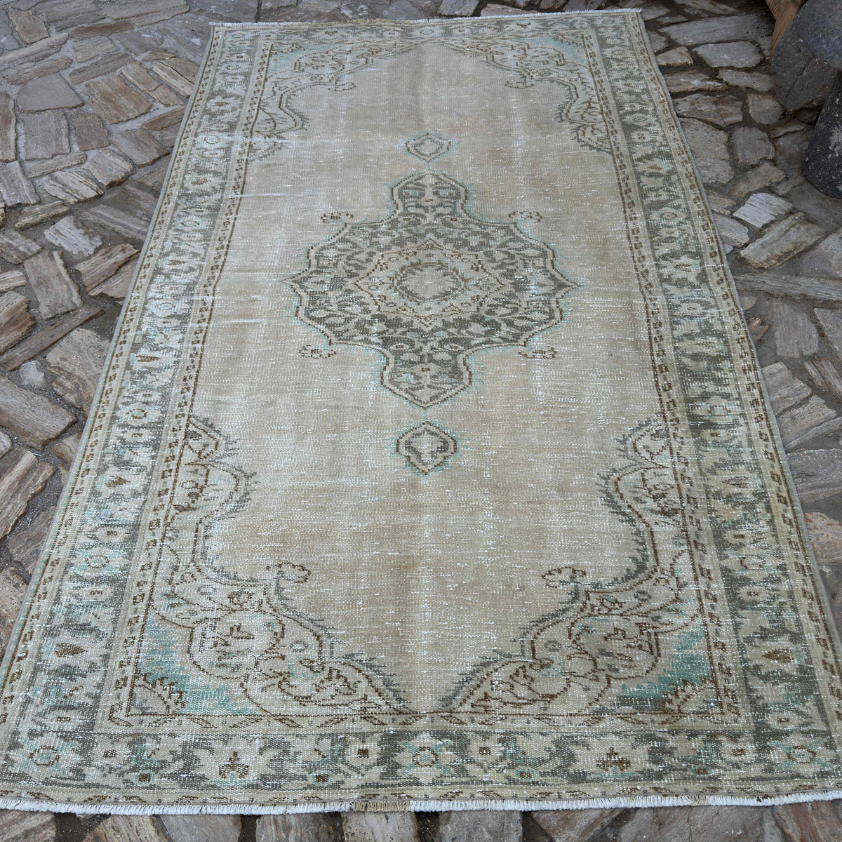 Beige 5' x 8' vintage Turkish distressed rug in wool and cotton, shown on the floor.
