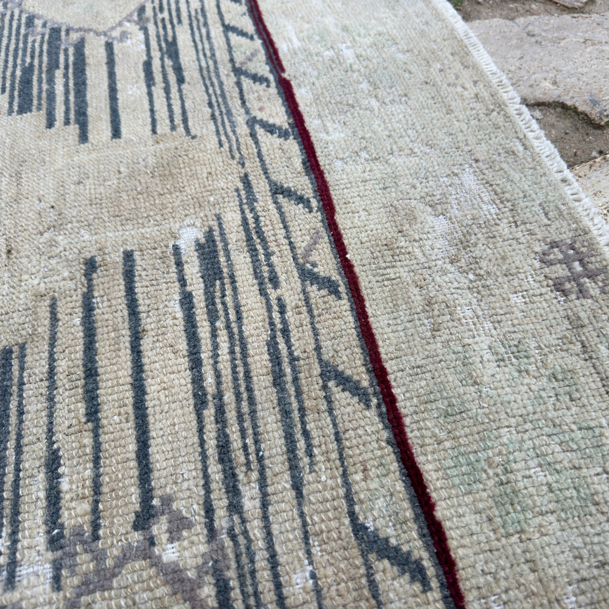 Close-up of the blue vintage Turkish distressed rug showing neutral details, hand-knotted weave, wool and cotton and low pile.