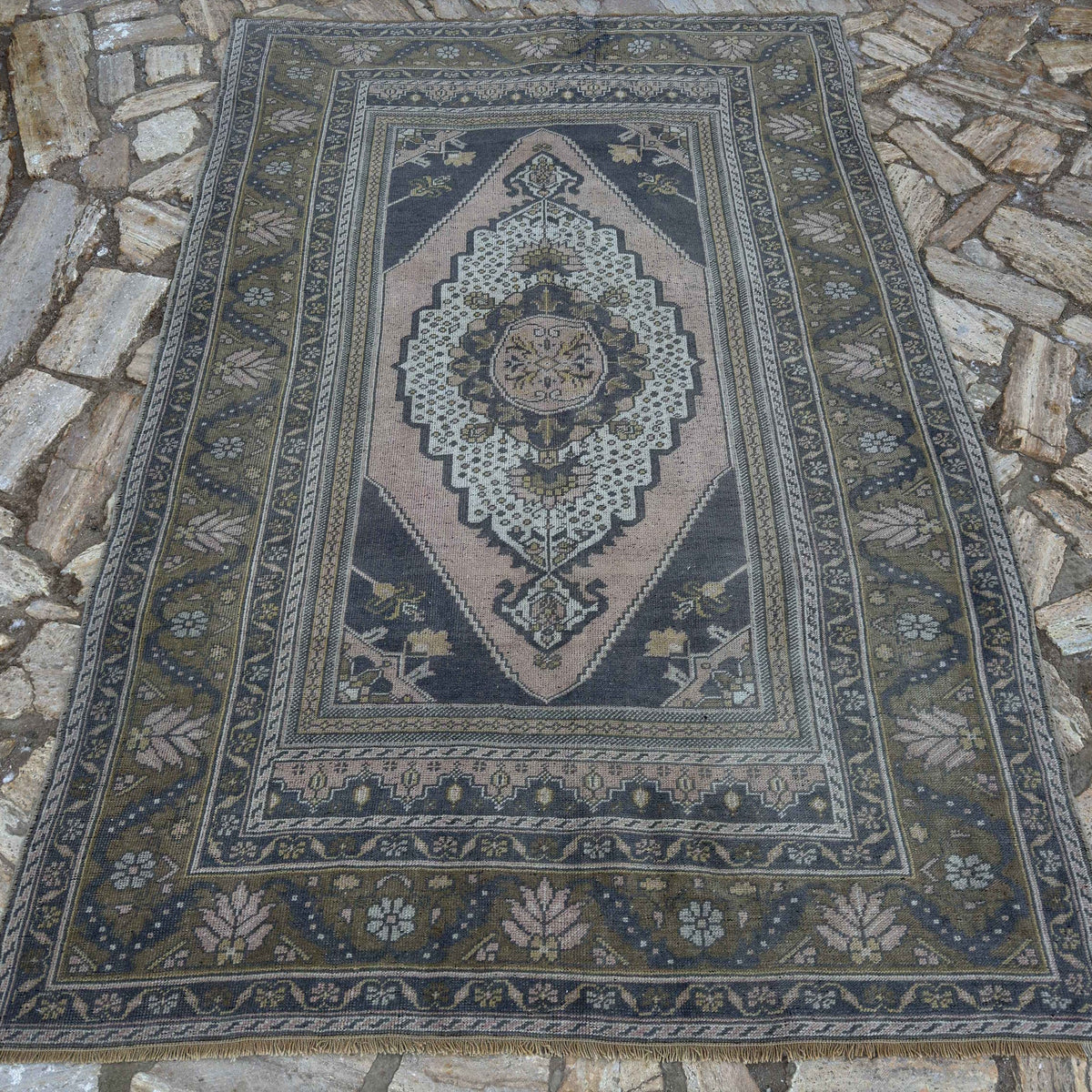 Pink 5' x 8' vintage Turkish distressed rug in wool and cotton, shown on the floor.