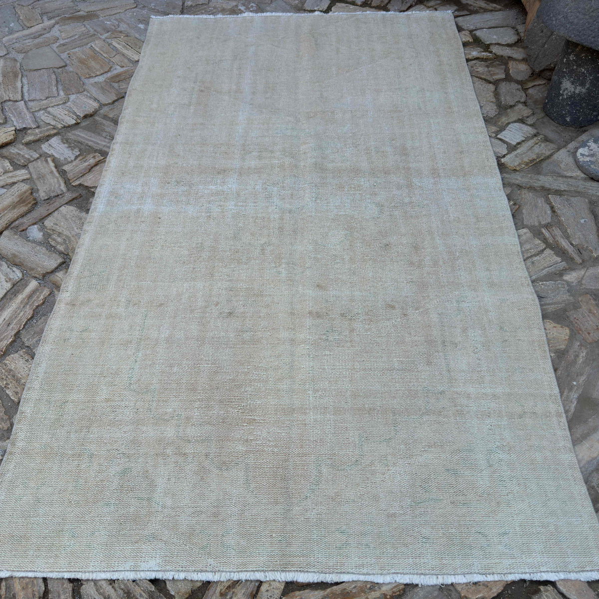 Beige 5' x 9' vintage Turkish distressed rug in wool and cotton, shown on the floor.
