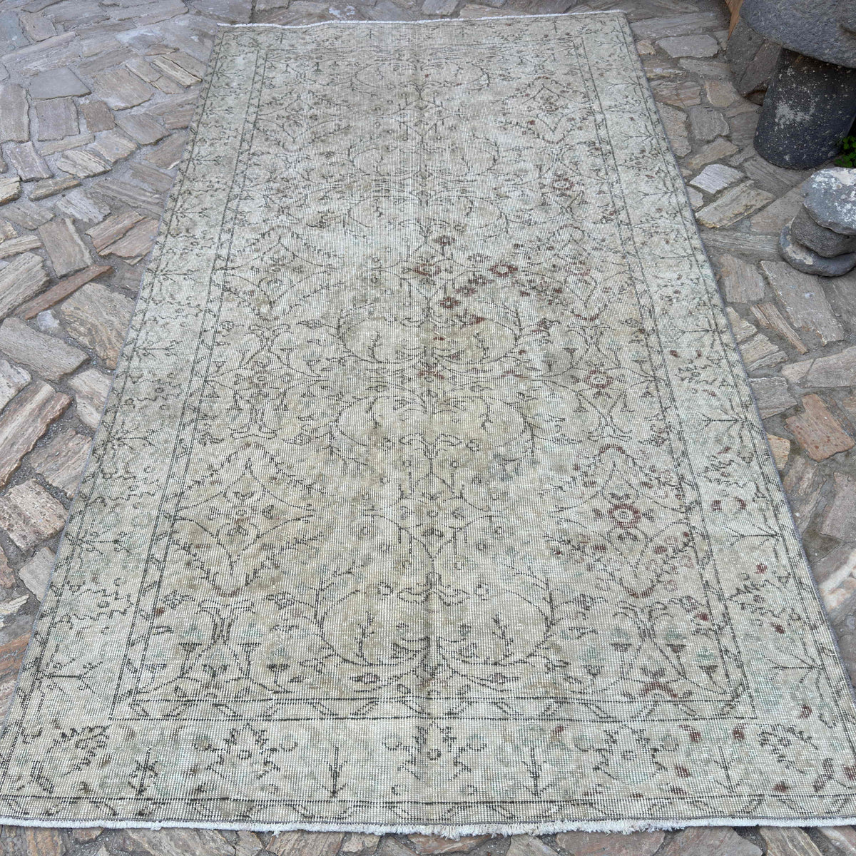 Beige 5' x 9' vintage Turkish distressed rug in wool and cotton, shown on the floor.
