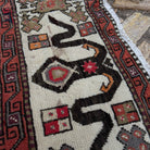 Close-up of the pale green vintage Turkish distressed rug showing traditional details, hand-knotted weave, wool and cotton and low pile.