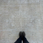 1970s beige vintage Turkish distressed rug with neutral design, hand-knotted weave and low pile.