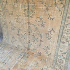 Beige 6' x 10' vintage Turkish distressed rug in wool and cotton, shown on the floor.