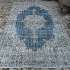 Blue 6' x 10' vintage Turkish distressed rug in wool and cotton, shown on the floor.