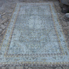 Blue 6' x 10' vintage Turkish distressed rug in wool and cotton, shown on the floor.