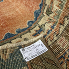 Close-up of the orange vintage Turkish distressed rug showing traditional details, hand-knotted weave, wool and cotton and low pile.