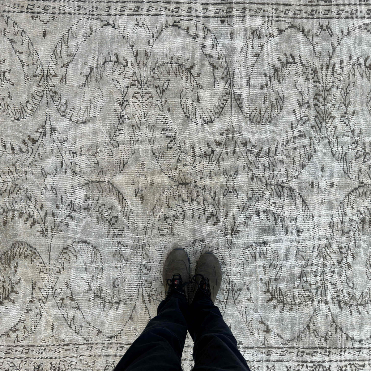 1970s beige vintage Turkish distressed rug with neutral design, hand-knotted weave and low pile.