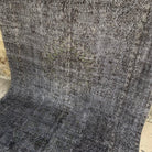 Black 6' x 9' vintage Turkish distressed rug in wool and cotton, shown on the floor.