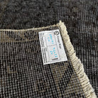 1970s black vintage Turkish distressed rug with overdyed design, hand-knotted weave and low pile.