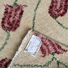 1970s beige vintage Turkish distressed rug with floral design, hand-knotted weave and low pile.