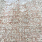 1970s pale pink vintage Turkish distressed rug with floral design, hand-knotted weave and low pile.
