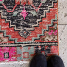 Close-up of the orange vintage Turkish distressed runner rug showing traditional details, hand-knotted weave, wool and cotton and low pile.