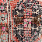 Orange 2' x 8' vintage Turkish distressed runner rug in wool and cotton, shown on the floor.