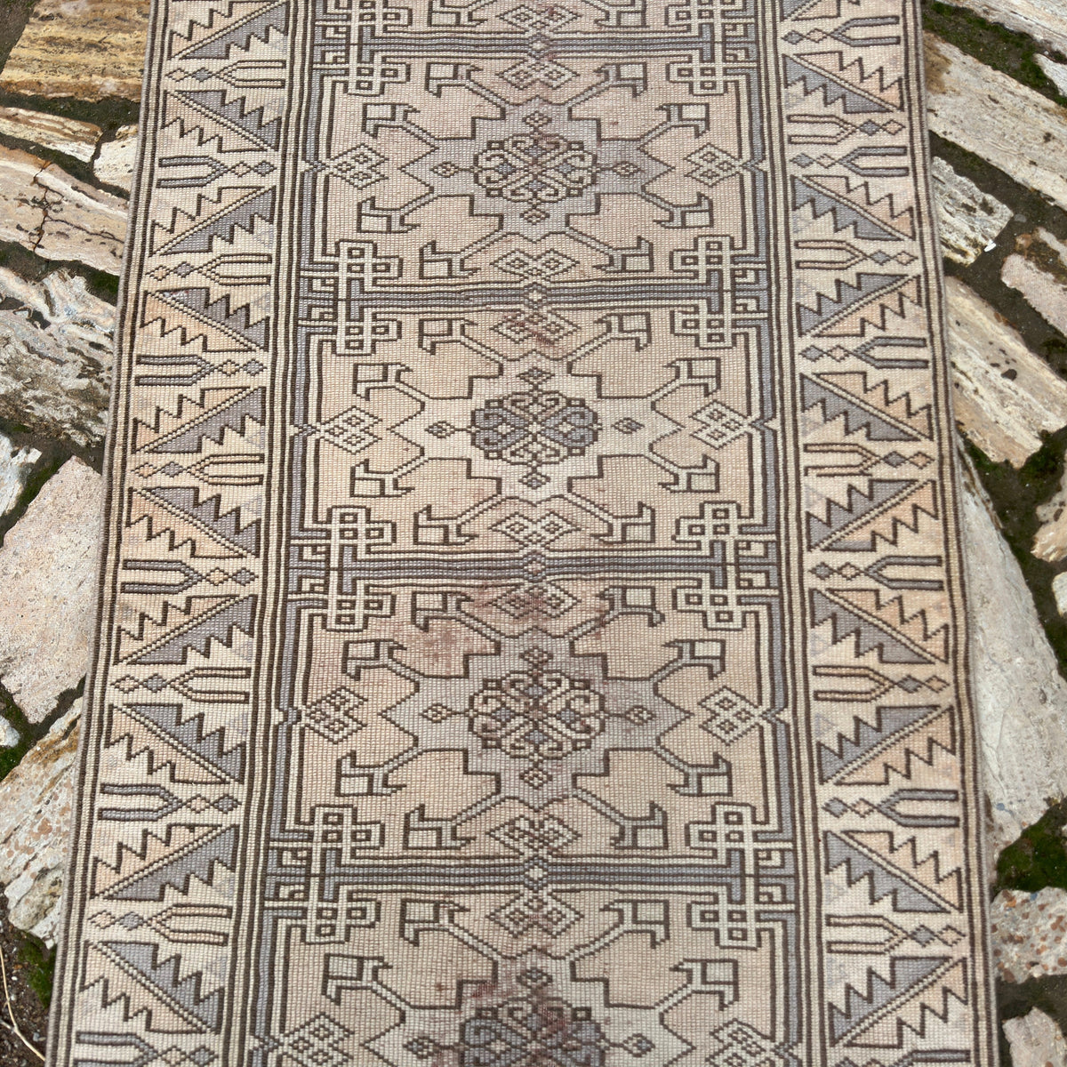 1970s beige vintage Turkish distressed runner rug with traditional design, hand-knotted weave and low pile.
