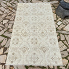 Beige 4' x 7' vintage Turkish floral rug in wool and cotton, shown on the floor.