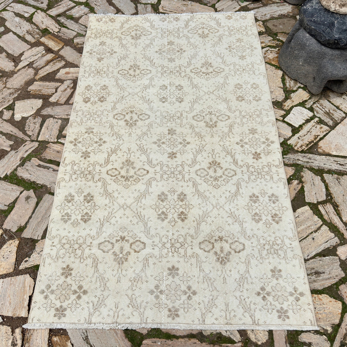 Beige 4' x 7' vintage Turkish floral rug in wool and cotton, shown on the floor.
