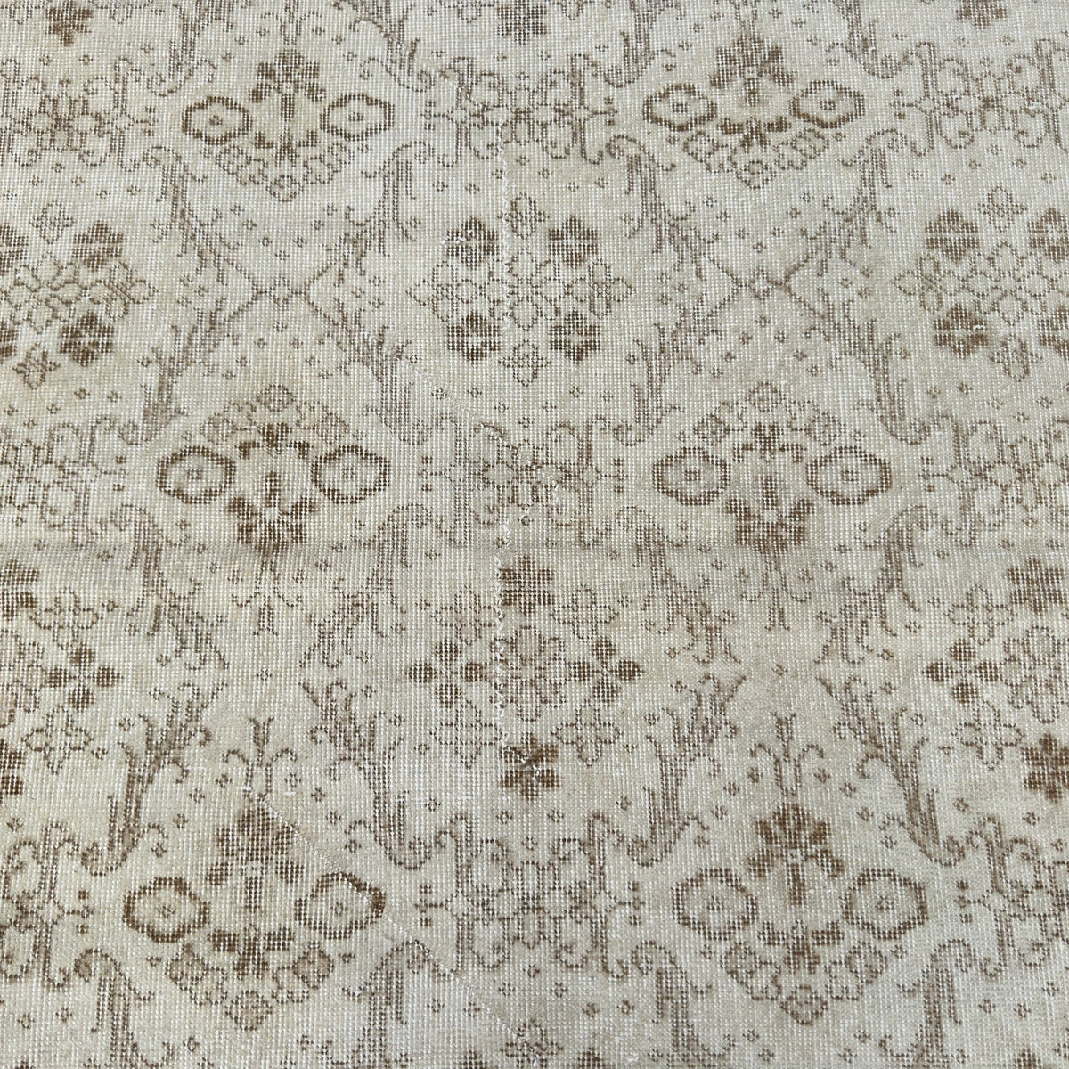 1970s beige vintage Turkish floral rug with geometric design, hand-knotted weave and low pile.