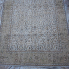 Close-up of the beige vintage Turkish floral rug showing floral details, hand-knotted weave, wool and cotton and low pile.