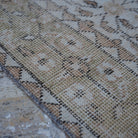 Beige 4' x 7' vintage Turkish floral rug in wool and cotton, shown on the floor.