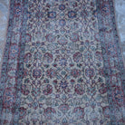 Close-up of the red vintage Turkish floral rug showing floral details, hand-knotted weave, wool and cotton and low pile.