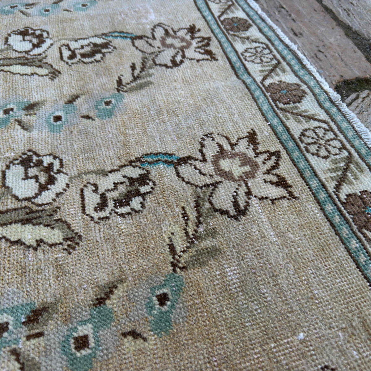 Close-up of the beige vintage Turkish floral rug showing floral details, hand-knotted weave, wool and cotton and low pile.
