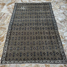 Close-up of the brown vintage Turkish floral rug showing floral details, hand-knotted weave, wool and cotton and low pile.