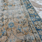 Close-up of the orange vintage Turkish floral rug showing floral details, hand-knotted weave, wool and cotton and low pile.