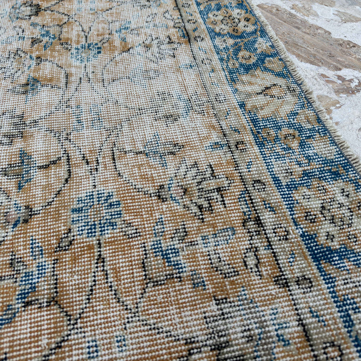 Close-up of the orange vintage Turkish floral rug showing floral details, hand-knotted weave, wool and cotton and low pile.
