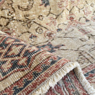 Close-up of the pale red vintage Turkish floral rug showing floral details, hand-knotted weave, wool and cotton and low pile.