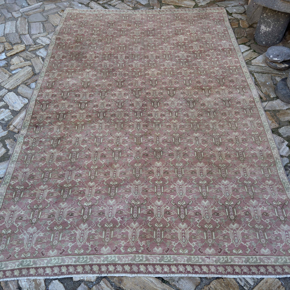 Pink 6' x 10' vintage Turkish floral rug in wool and cotton, shown on the floor.