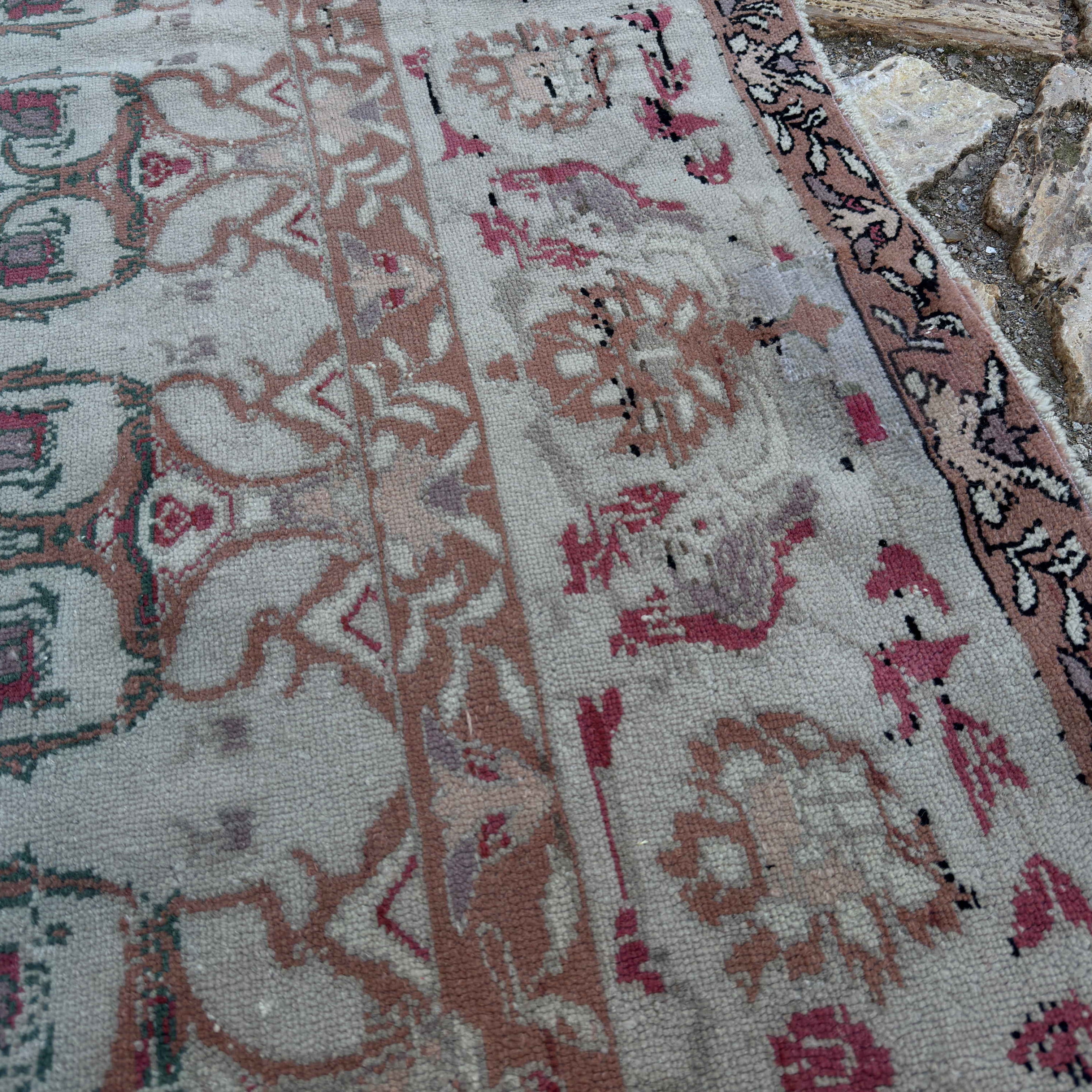 Close-up of the gray vintage Turkish floral rug showing floral details, hand-knotted weave, wool and cotton and low pile.